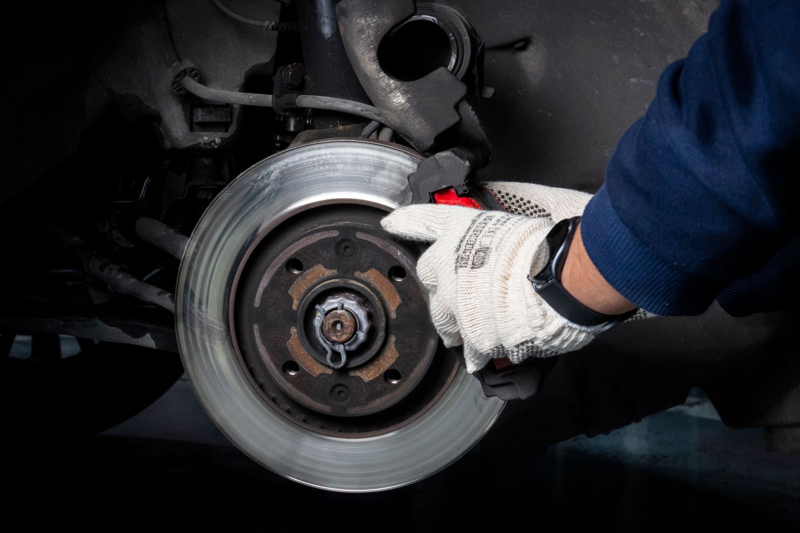 Close-up of a mechanic working on a vehicle brake assembly