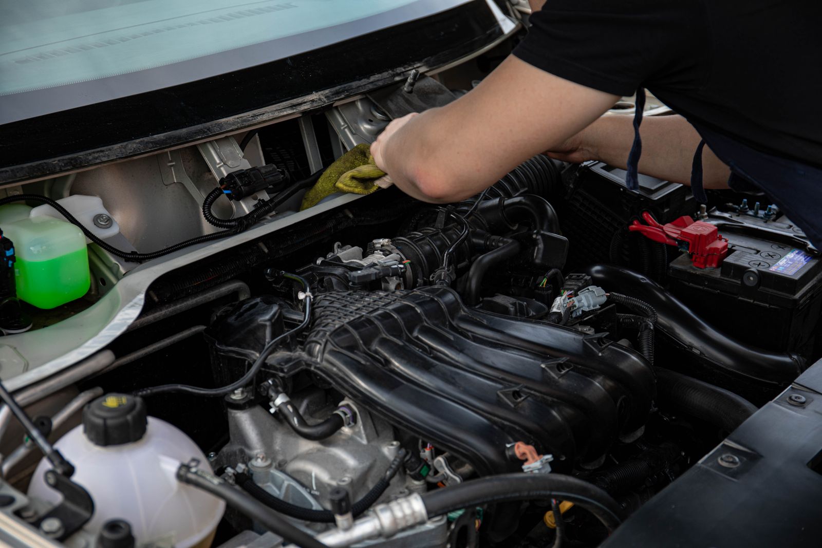 Mechanic inspecting the engine area of a vehicle